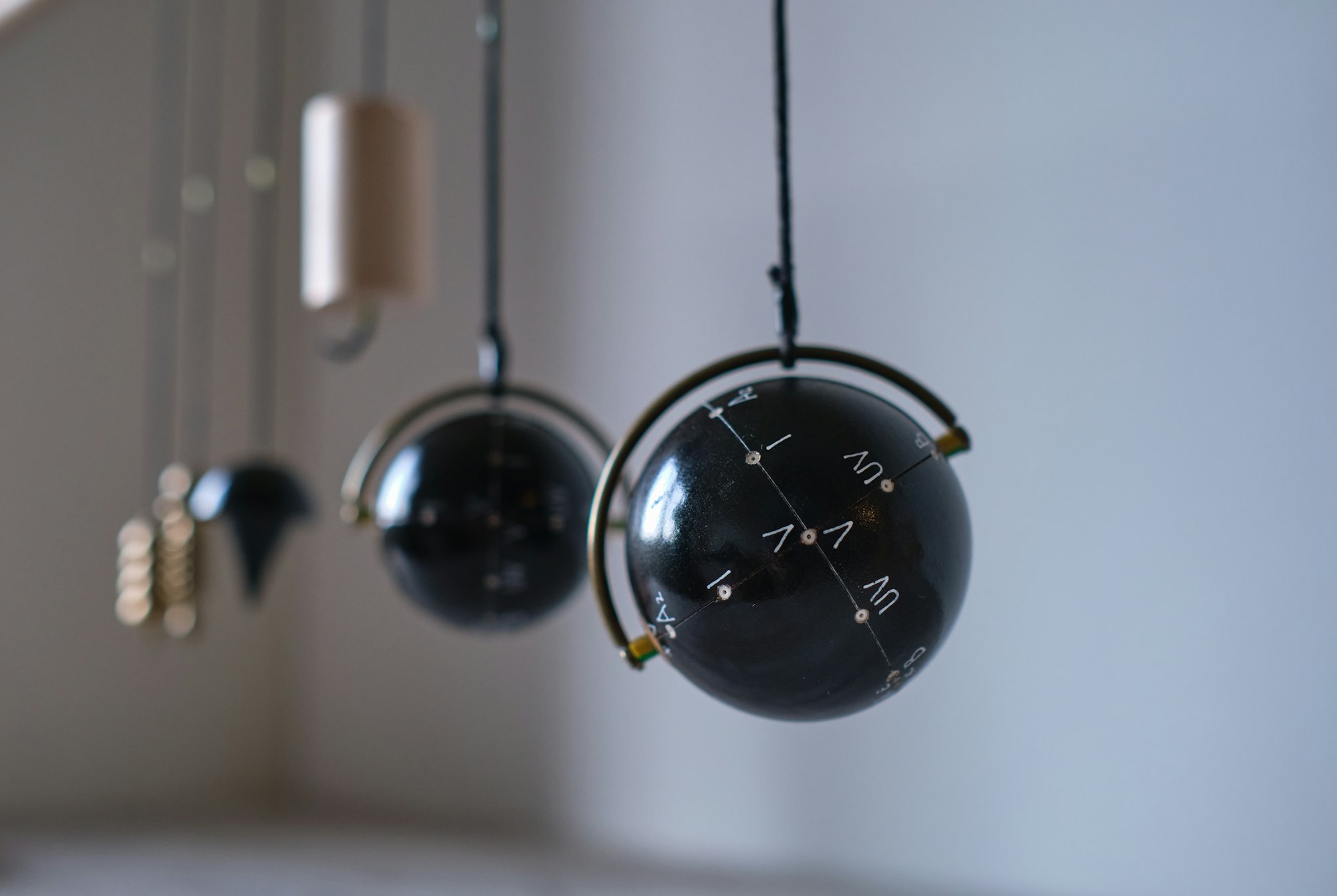 Closeup shot of a round-shaped dowsing pendulum hanging from a wall